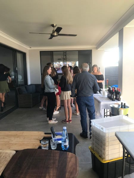 Guests standing with drinks on a covered patio at a private party